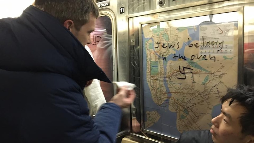 Commuter cleans swastika off subway map.