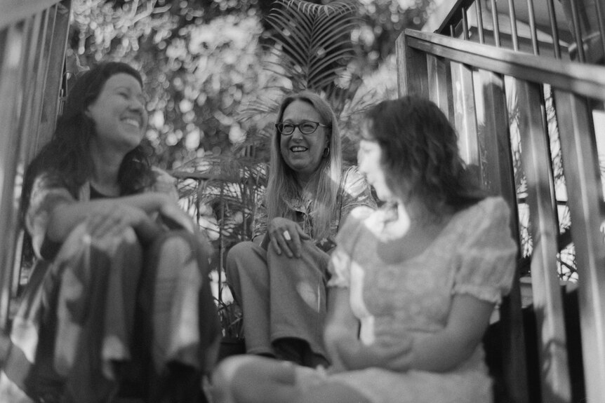 Three women smiling in black and white photo