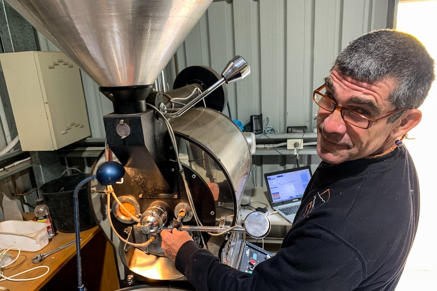 Bernard Rooney checks on a batch of coffee he's roasting.