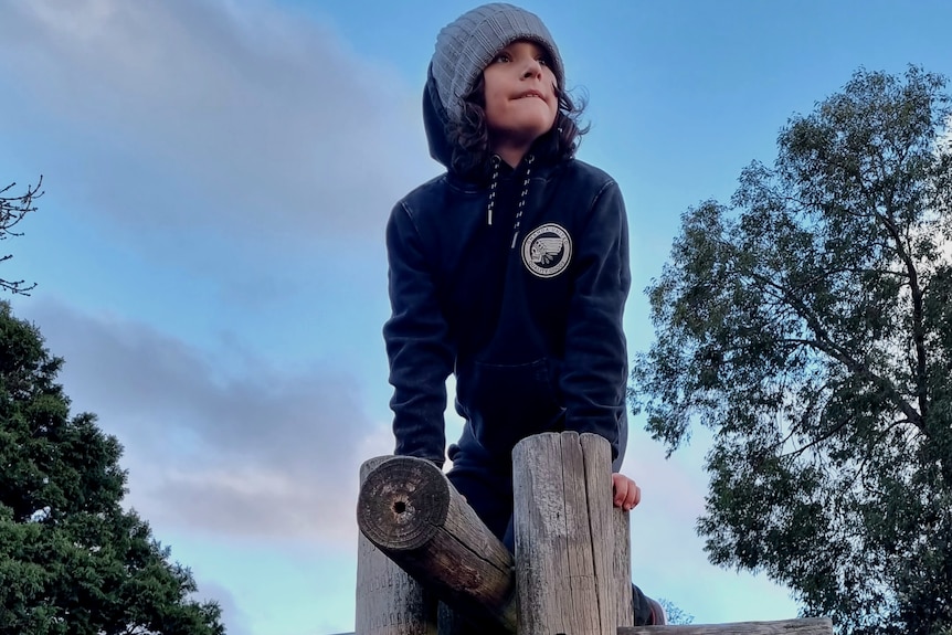 A boy climbing on playground equipment.