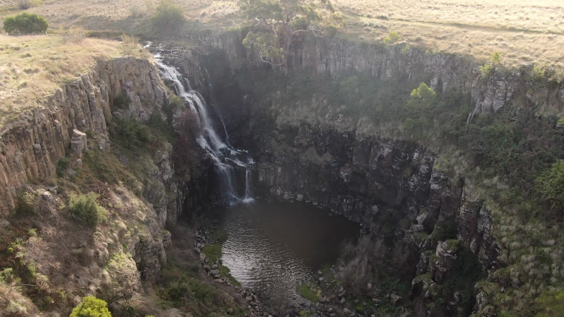 An overhead aerial image of a waterfall and full basin