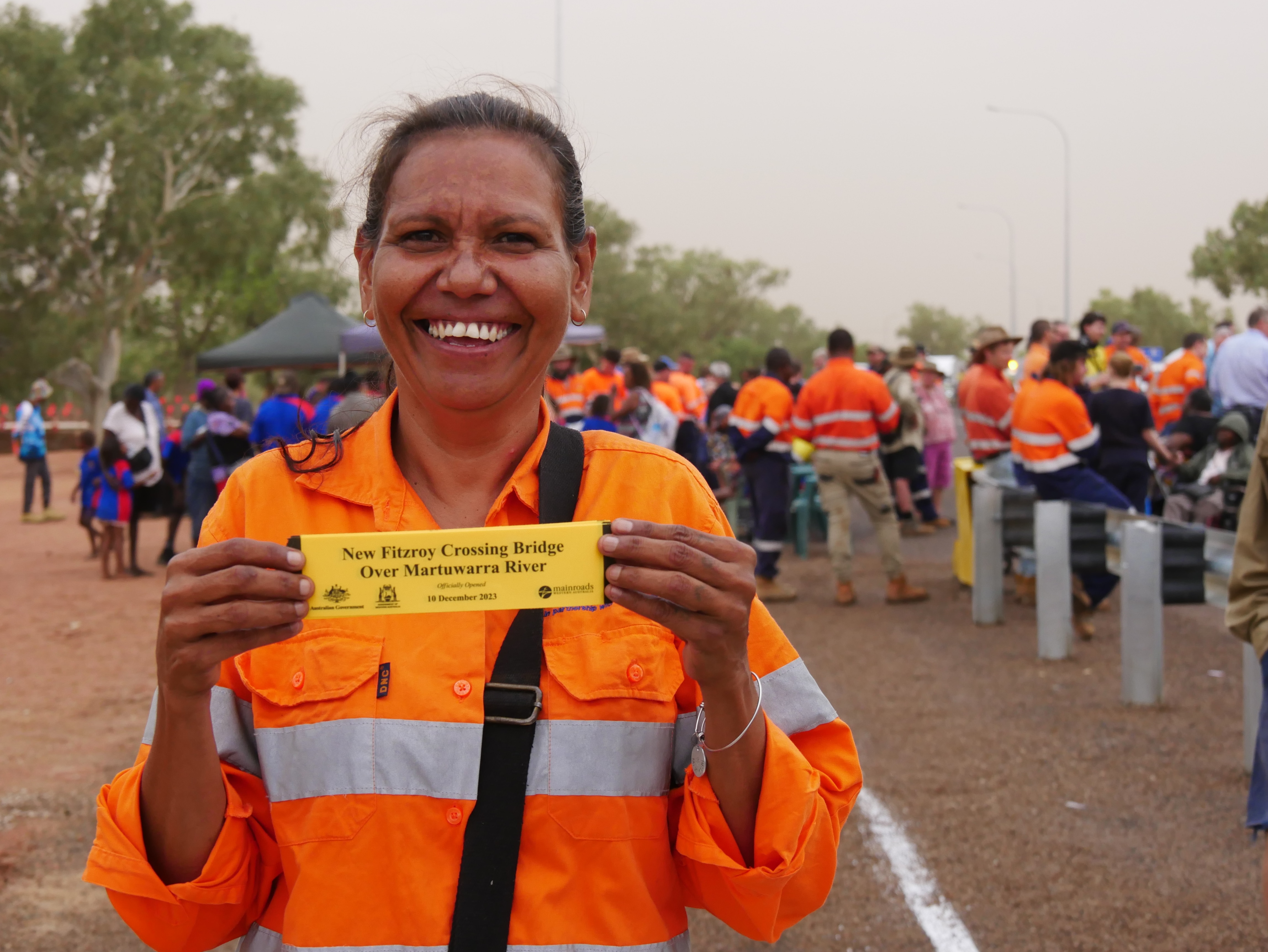 A woman holding a plackard in outback