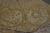 Faint circular carvings are visible on a larger stone, moss is dotted over the surface