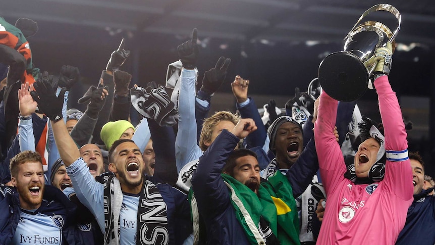 Jimmy Nielsen of Sporting Kansas City celebrates with the MLS Cup and team-mates.
