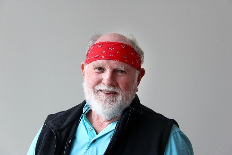 A man in a red bandana smiles for the camera