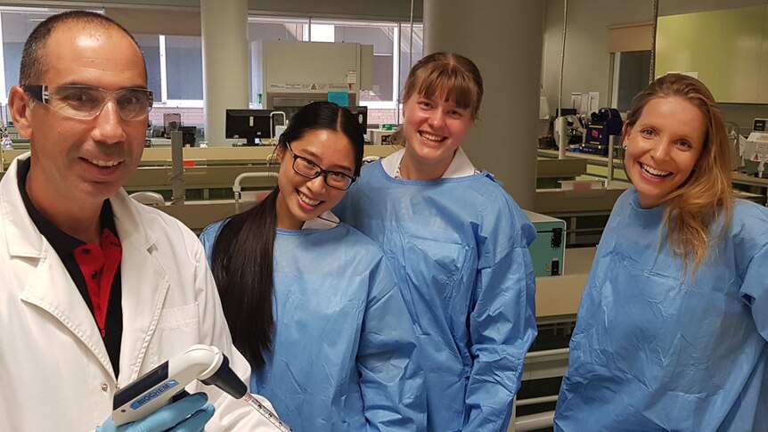 Dr Rebecca Allen with colleague and students in laboratory.