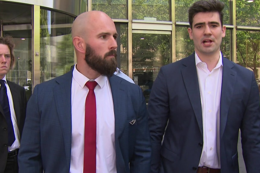 Two men wearing suits standing outside a Melbourne court