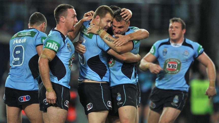 Blues players celebrate Trent Merrin's (centre) try