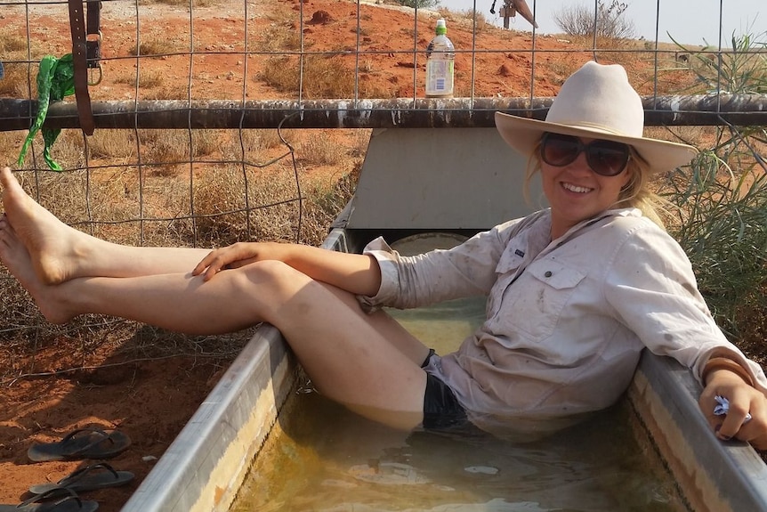 woman in cowboy hat sitting in outback bath tub