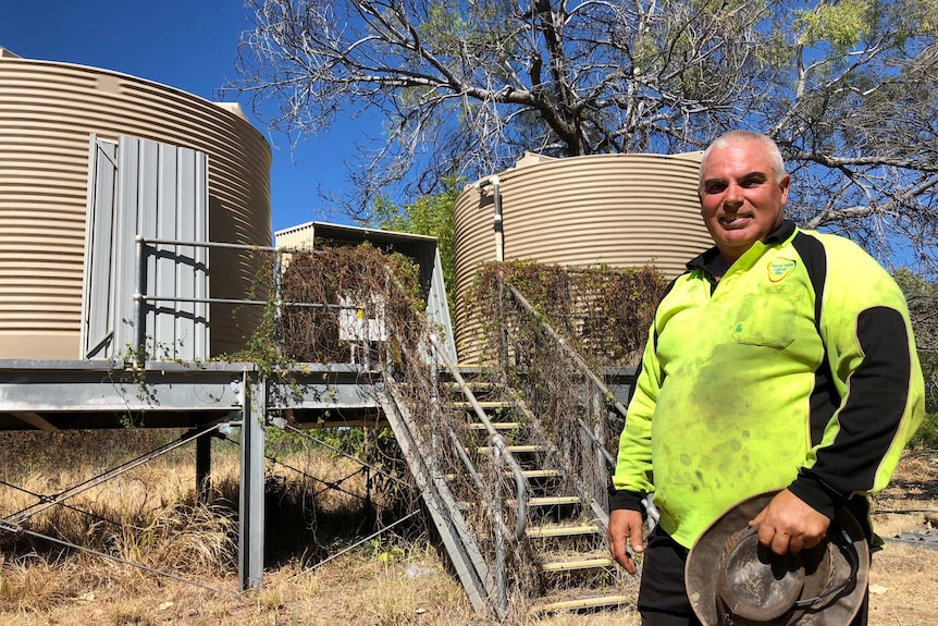 Image of Darlngunaya resident Bundy Aksenov with the remote community's current water infrastructure.