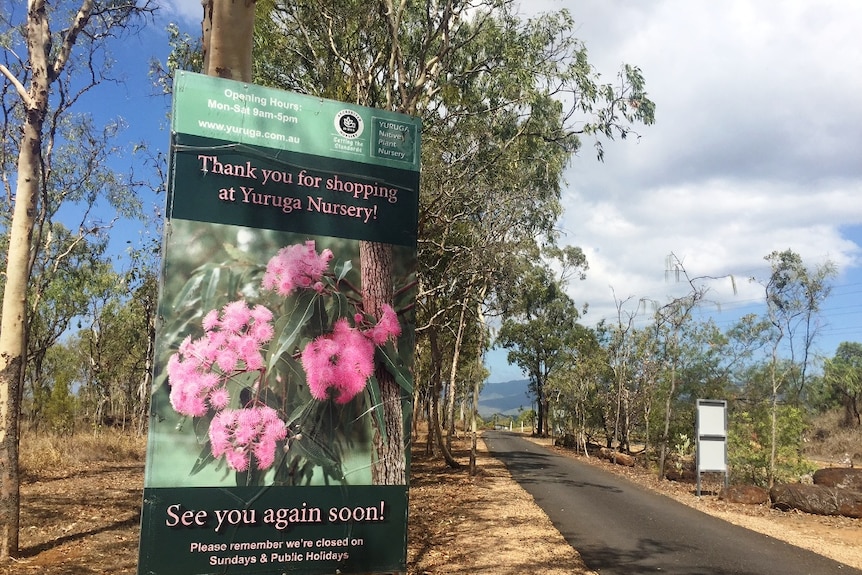 A large sign depicting bright pink flowers farewells visitors to the Yuruga Nursery