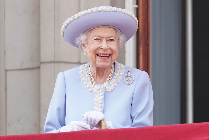 Queen Elizabeth II smiles as she watches from the balcony of Buckingham Palace 