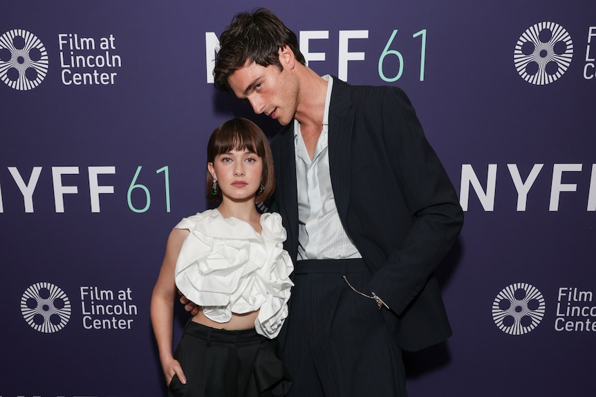 Cailee Spaeny stands next to Jacob Elordi, who is head and shoulders taller than her.