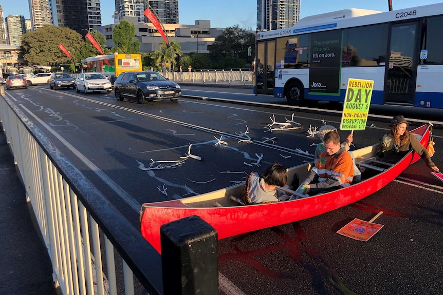 Protesters sitting in a canoe on the Brisbane Victoria bridge.