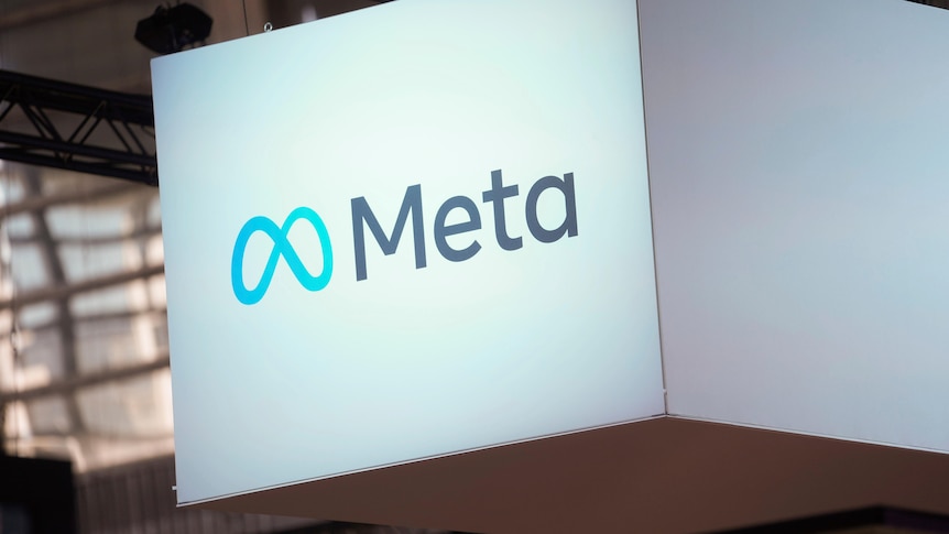 The logo for Meta is printed on a white box floating from the ceiling