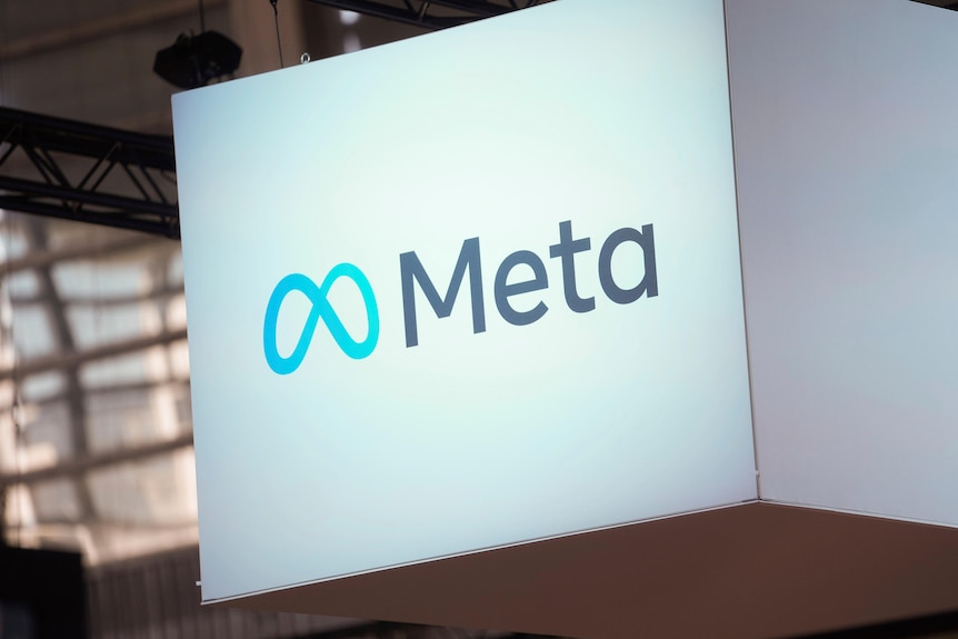 Das Logo für Meta ist auf eine weiße Box gedruckt, die von der Decke schwebt