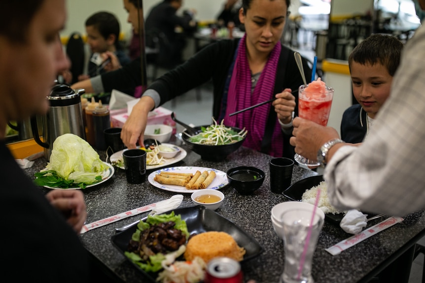 A family sitting down to a meal at a Vietnamese restaurant. 