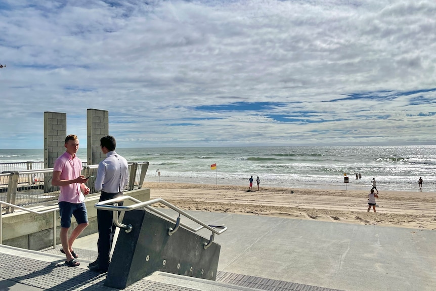 Two men stand on surfers paradise beach