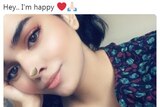 Rahaf Mohammed smiles underneath the text 'hey.. i'm happy'