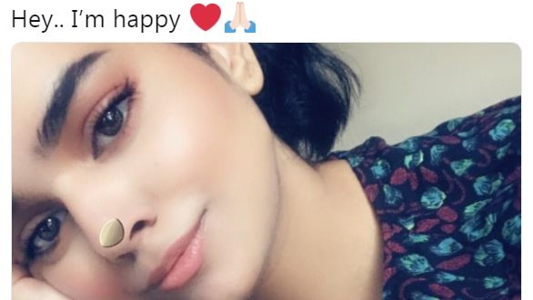 Rahaf Mohammed smiles underneath the text 'hey.. i'm happy'