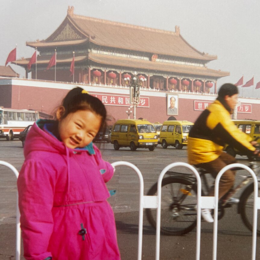 Emily Sun as a child wearing a pink parker in front of The Forbidden City in Beijing.