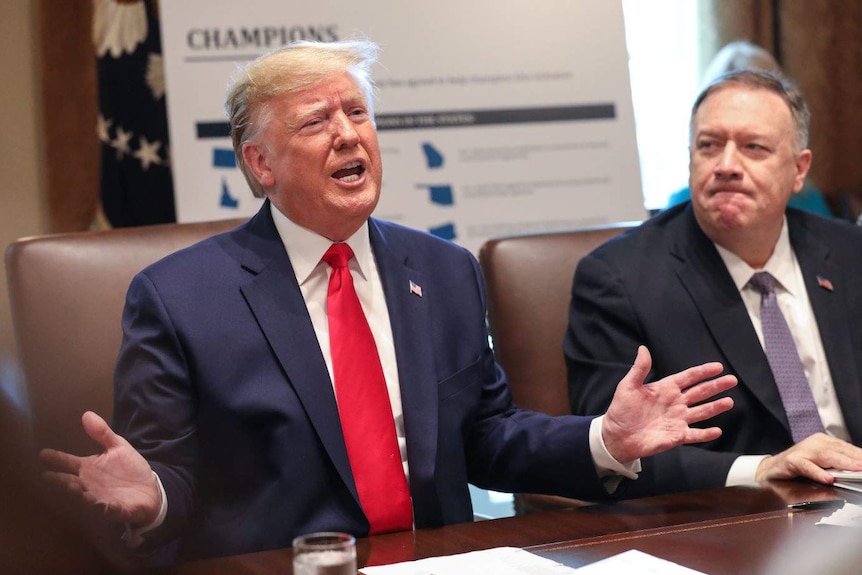 Donald Trump gesticulating while Mike Pompeo watches on