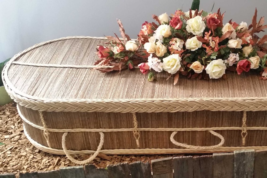 A casket made from woven fibres. Flowers on lid.