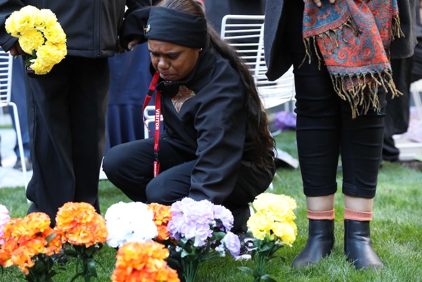 Women lay flowers outside Parliament House