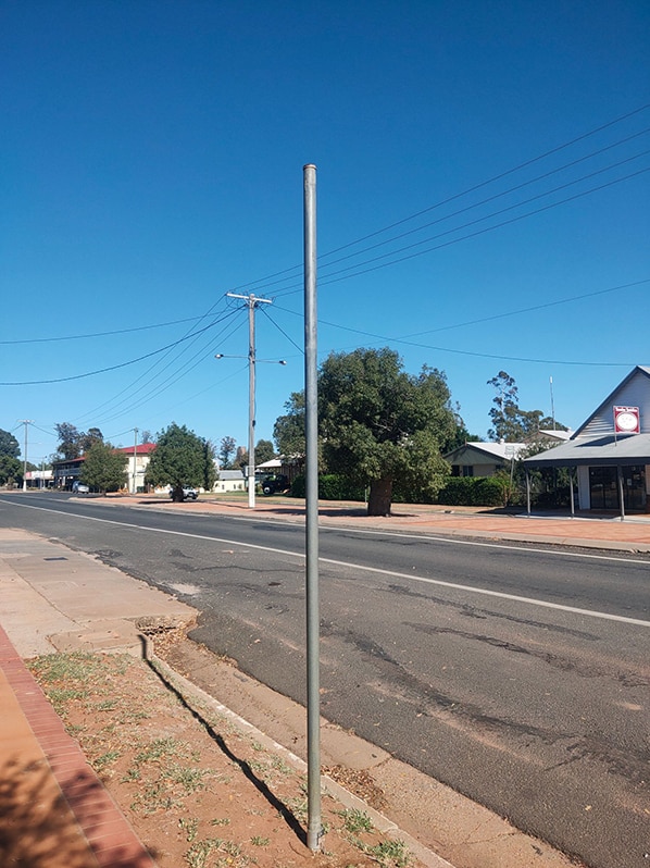 An empty pole stands on the side of the main street in a quiet outback town.