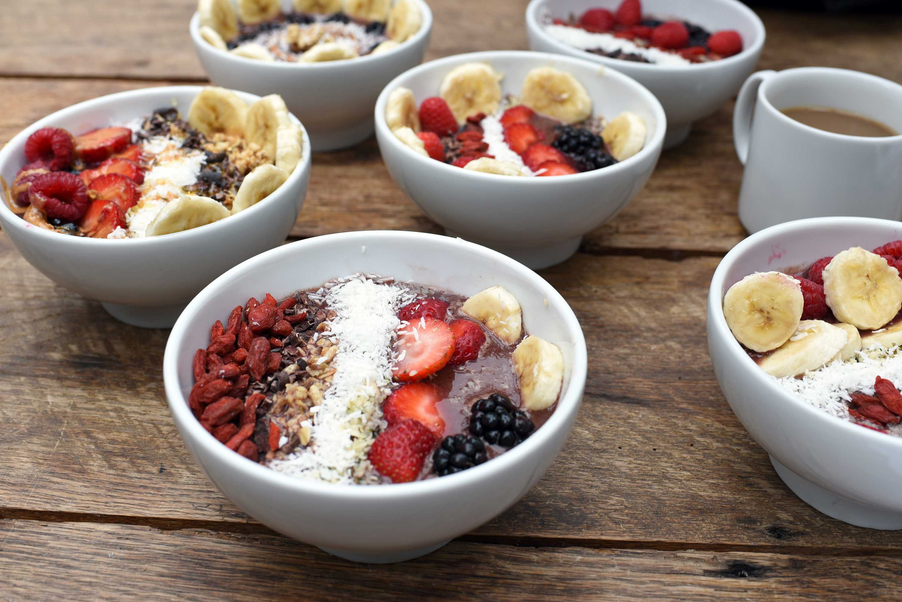 A bowl of acai with fruit and goji berries.