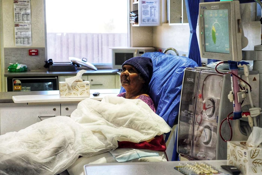 Mavis Holmes sits in a chair undergoing dialysis treatment.