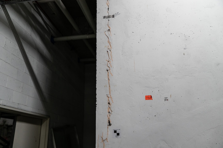 Cracks running down a wall in a basement. 