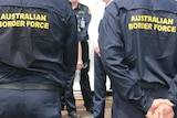 An image of the backs of two Border Force officers, their organisation clearly shown by signs on their backs