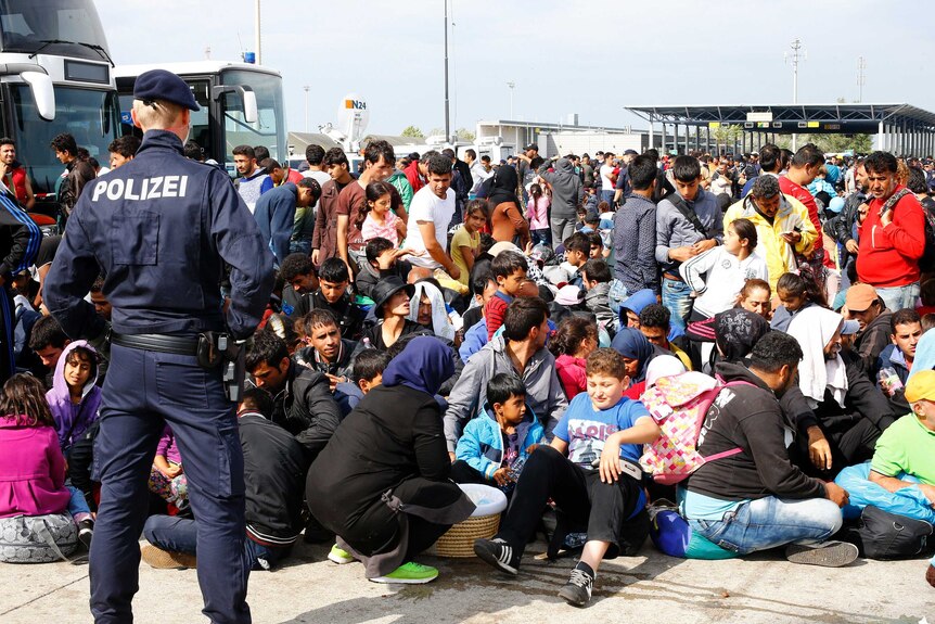 Migrants wait to board busses in Nickelsdorf, Austria