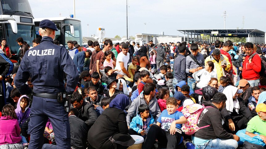 Migrants wait to board busses in Nickelsdorf, Austria