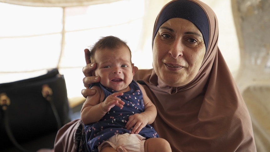 Hiam Zahab cuddles an Australian baby in the al-Hawl camp in Syria