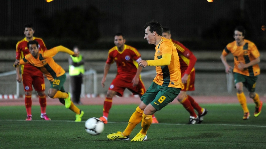 Luke Wilkshire scores Australia's opening goal against Romania in Malaga.