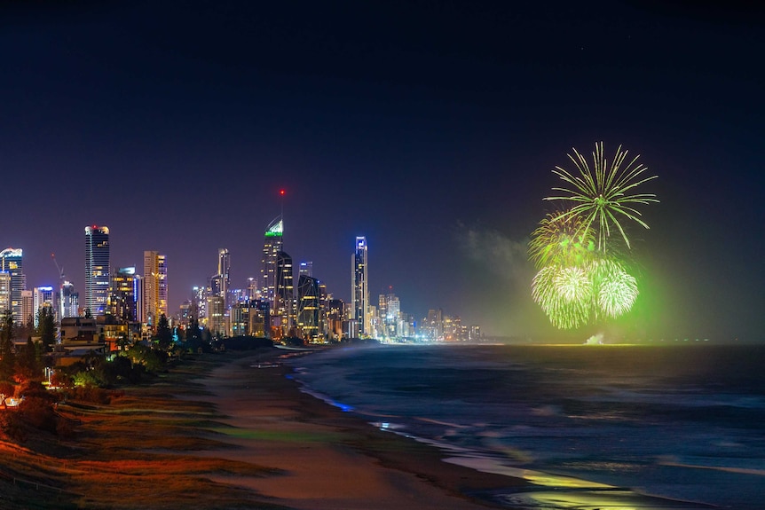 night time picture of surfers paradise skyline and beachline with fireworks over the ocean