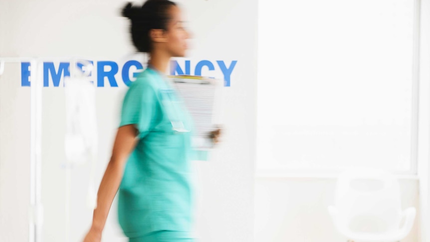 Nurse walks through hospital emergency department.