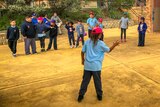 Primrary aged Aboriginal students playing handball in the school yard