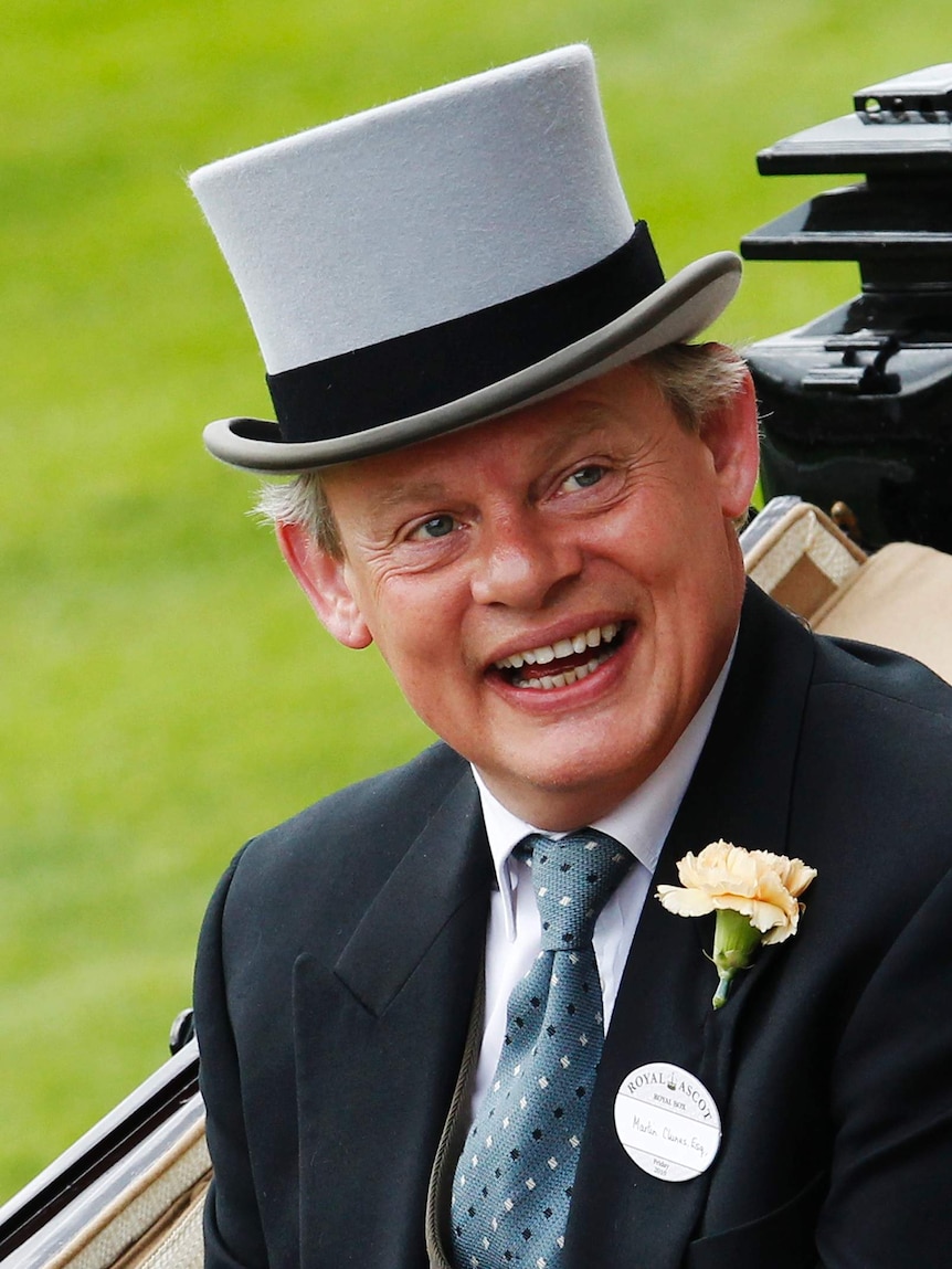 Martin Clunes smiles as he wears a top hat