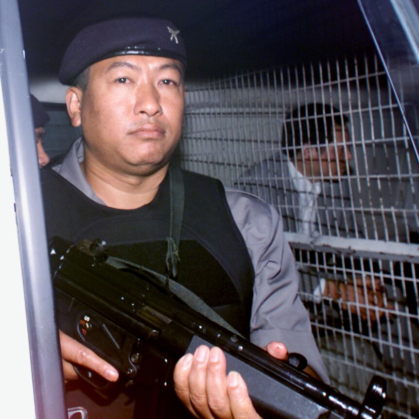A police officer holds a long gun.