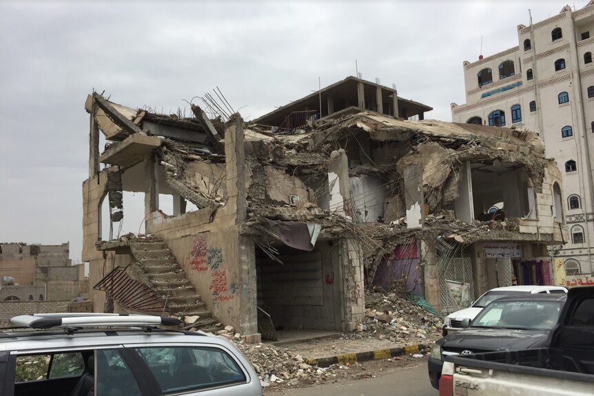 A house hit by airstrikes in Sanaa. External walls have been destroyed, it is covered in rubble and exposed metal.