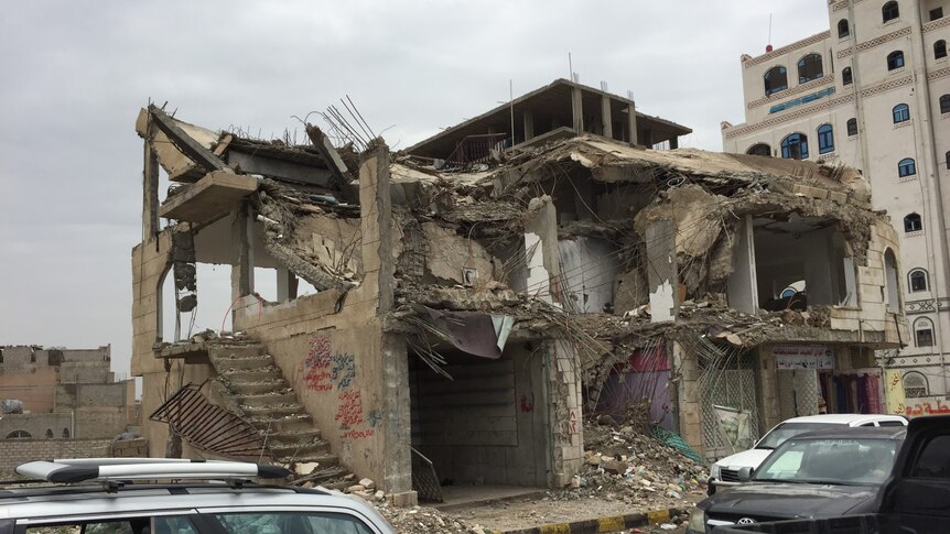 A house hit by airstrikes in Sanaa. External walls have been destroyed, it is covered in rubble and exposed metal.
