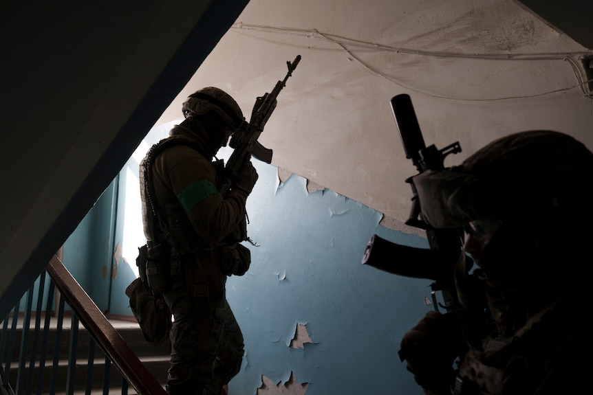 Security Service of Ukraine (SBU) servicemen enter a building during an operation.