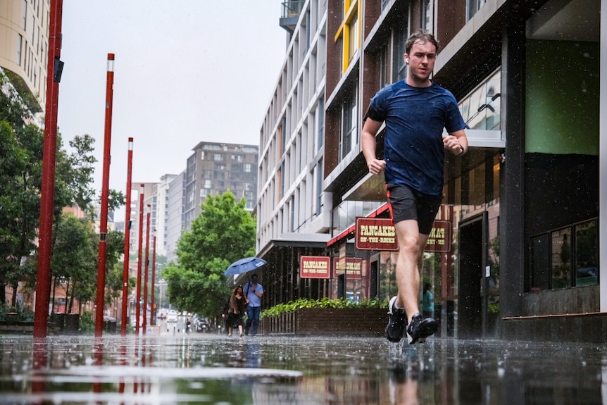 a man jogging in the rain through the city