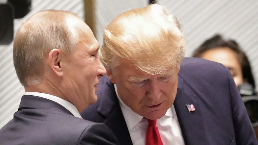 Russian President Vladimir Putin smiles as he speaks into US President Donald Trump's ear.