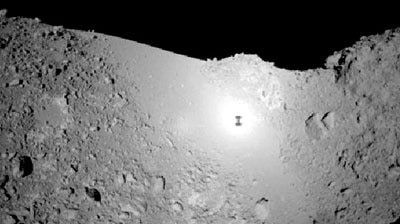 The Hayabusa probe's shadow (tiny black spot seen on centre) is made out on the asteroid's surface.