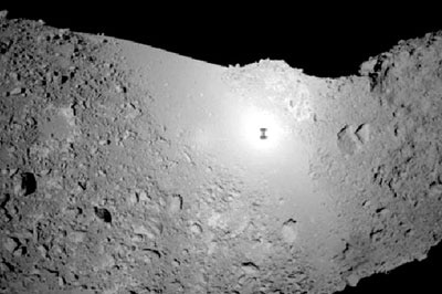 The Hayabusa probe's shadow (tiny black spot seen on centre) is made out on the asteroid's surface.