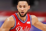 Ben Simmons dribbles the ball with his left hand while sizing up a defender in front of him